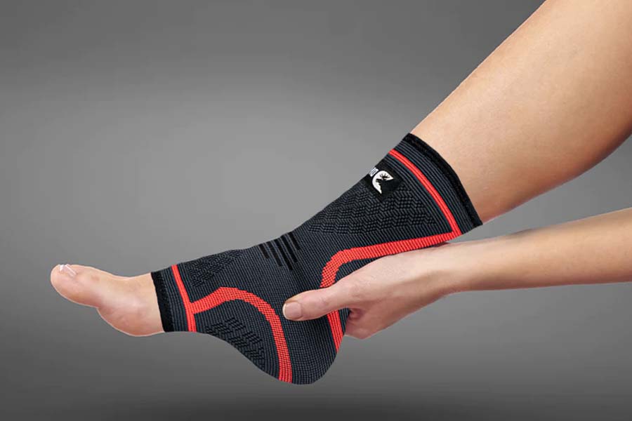 A man is wearing DMoose Compression Ankle Sleeve