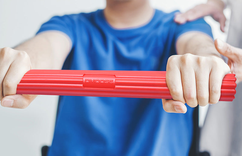 A man demonstrating a boy how to use DMoose flexbar