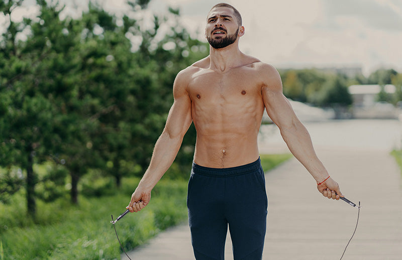 A man is skipping using DMoose jumping rope in his garden