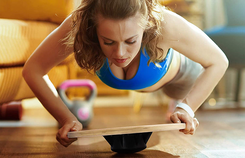 A woman doing core strengthening exercise using DMoose balance board