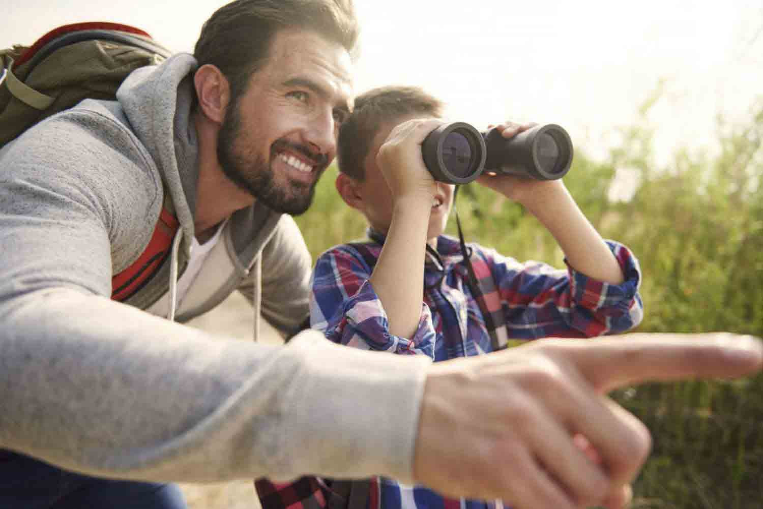 Man and son using binoculars 