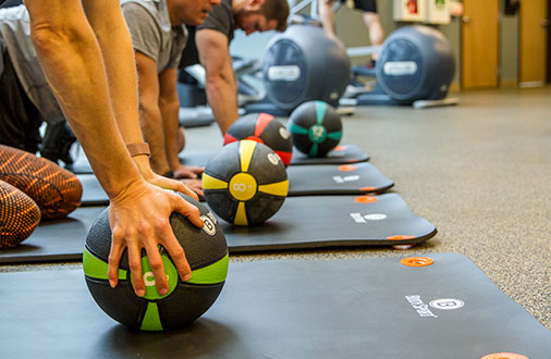 Group using medicine balls in gym