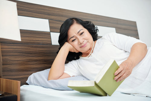 senior woman reading in bed