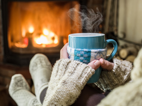 relaxing by fireplace with a hot mug