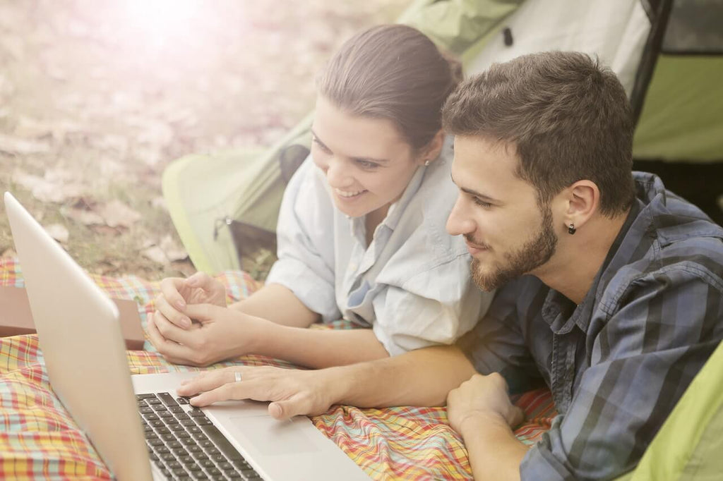 Couple using battery in camping tent