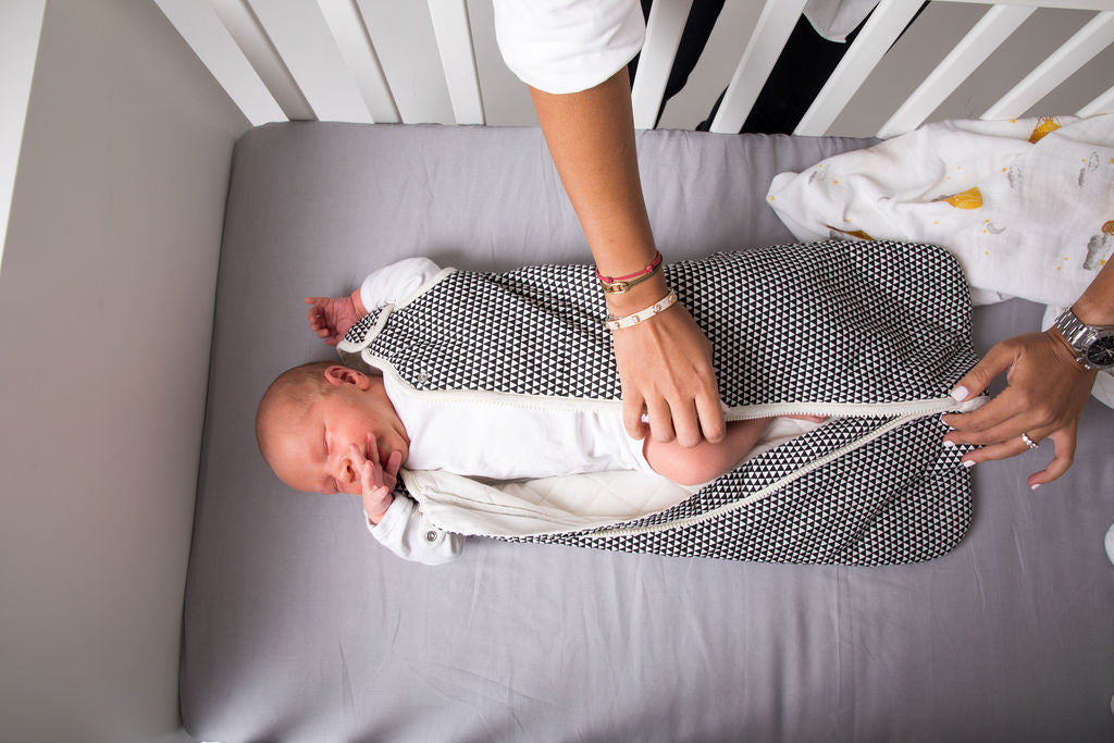 Zipping baby into sleep bag