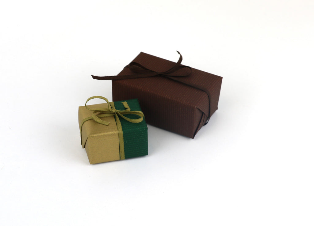 Two gift boxes that have tencel ribbon wrapped around them.