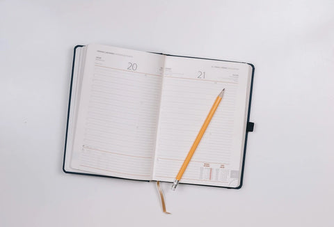 Open agenda notebook with pencil