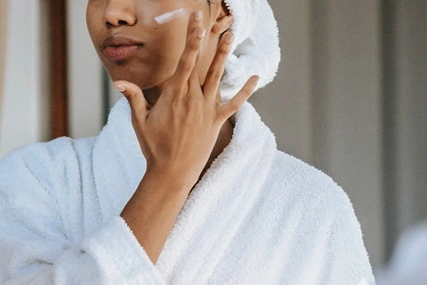 Woman applying cream to her face