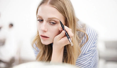 Woman applies eyebrow makeup