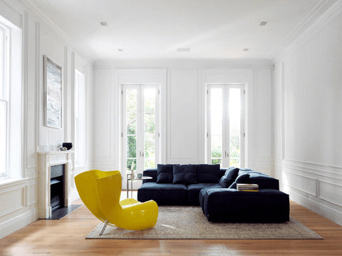 A bold arm chair sits in a subdued minimalist room