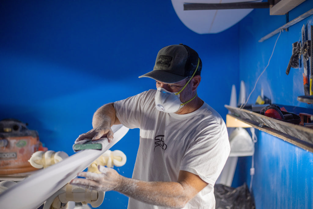 David Farina of Shred Season Surfboard shaping a custom for a South Carolina surfer in his shaping room.