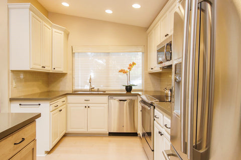 After Photo of Remodeled Kitchen with White Painted Cabinets, Stainless Steel Appliances and Quartz Countertops