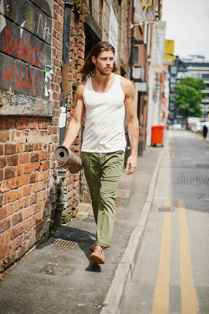 Twill longs in forest, walking with a yoga mat on the street