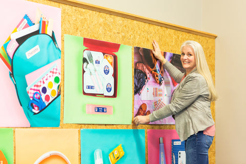 Michelle Brandriss smiling in front of a colorful classroom wall and celebrating $200,000 in Name Bubbles giving.