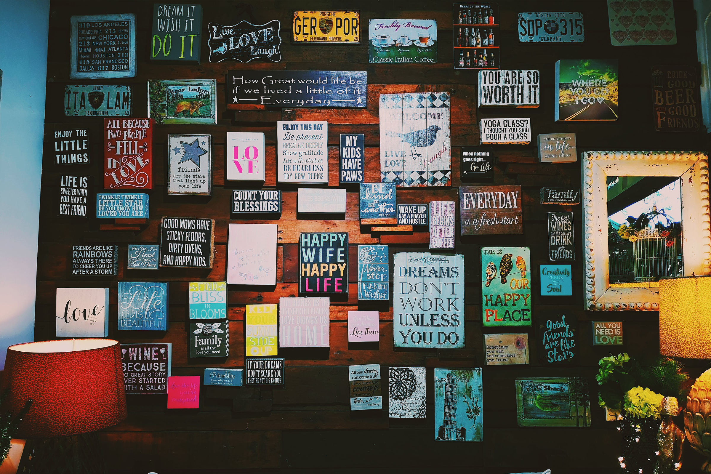 A wooden wall with a lot of signs on it