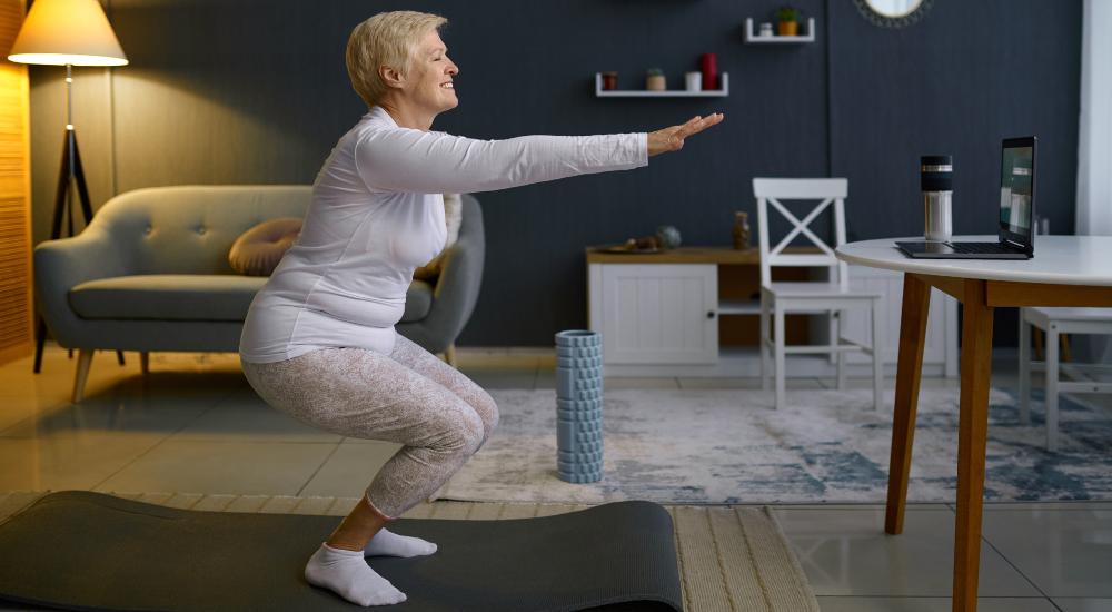 Senior woman doing balance exercise at home