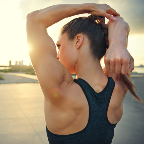 Young woman stretching arms outdoors