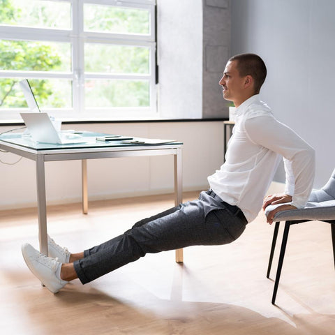 Man doing exercise with chair at the office