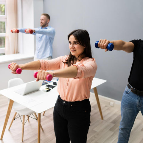 Group of office workers exercising with dumbbells at work