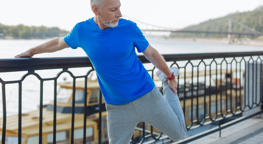 Man over 50 stretching outdoors before going for a run