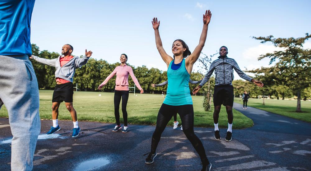 Group of young people doing jumping class in outdoors fitness class