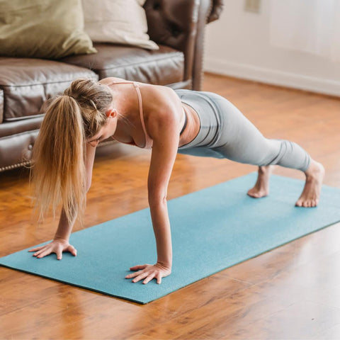 Woman performing plank exercise in living room