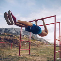 Man performing calisthenics workout on monkey bars