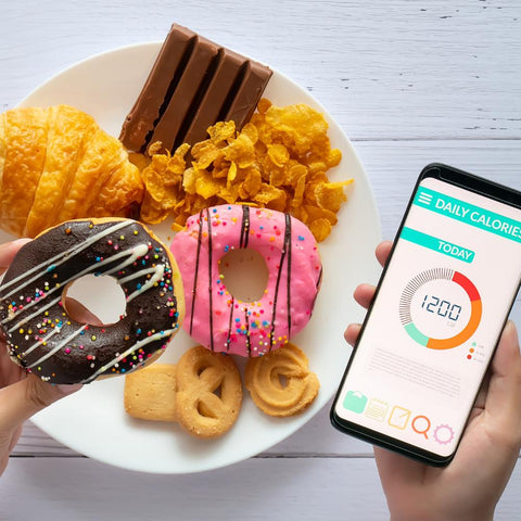 Person holding donut on their left hand and phone with calories app open on their right hand