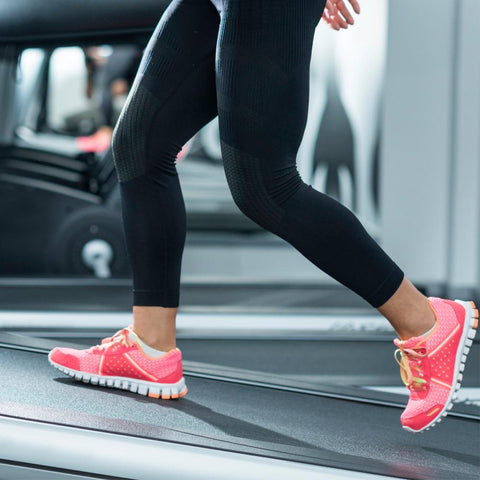 Woman incline walking on treadmill