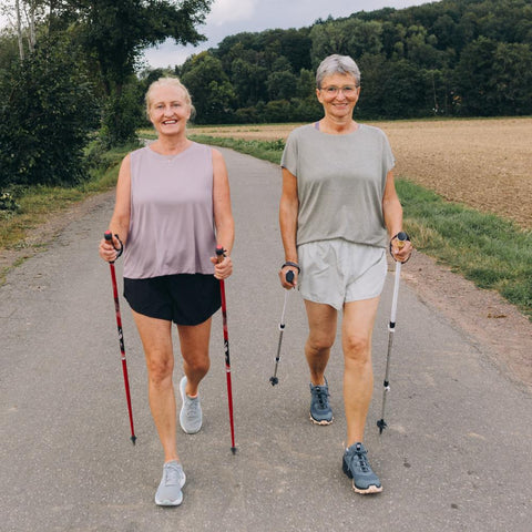 Two women nordic walking with walking sticks outdoors