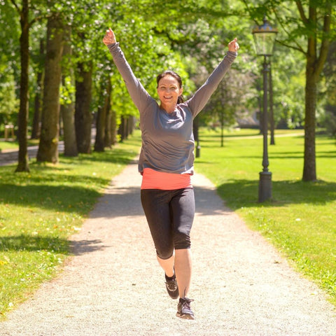 Women jumping in celebration outdoors after jogging