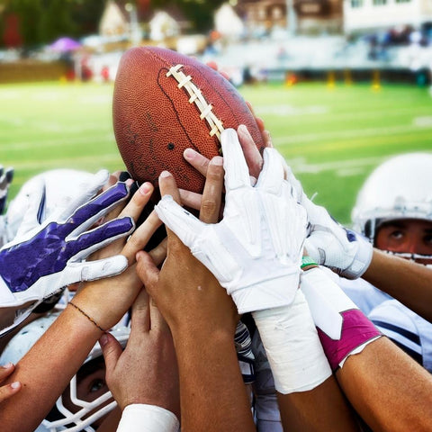 Football player huddling around ball before match