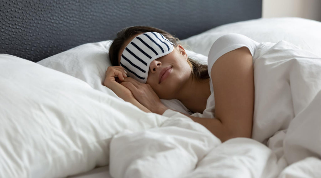 Woman with eye mask peacefully sleeping on comfortable bed