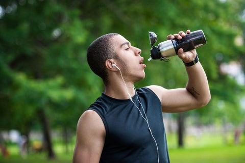 A runner drinking from a water bottle