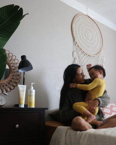 Mom hugging son while sitting on their bed