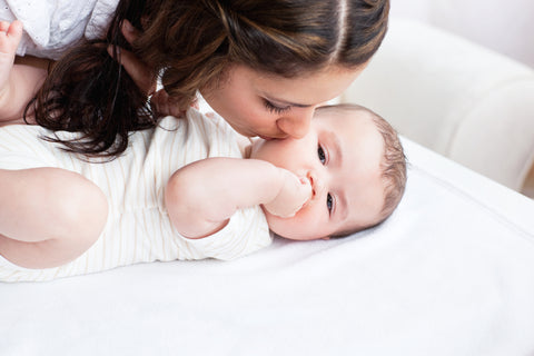 mom kissing newborn cheek