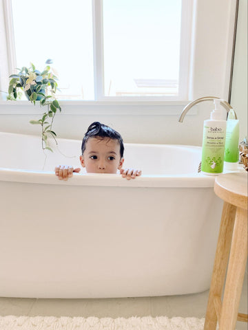 Kid peeking through the bath tub