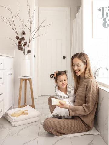 Mom showing daughter what products she uses during bath time