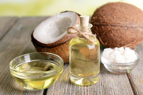 Open coconut next to a bottle of coconut oil