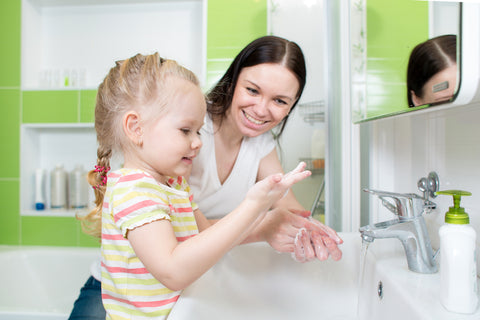 mom and daughter washing hands together