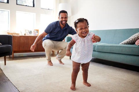 Happy baby walking with proud dad