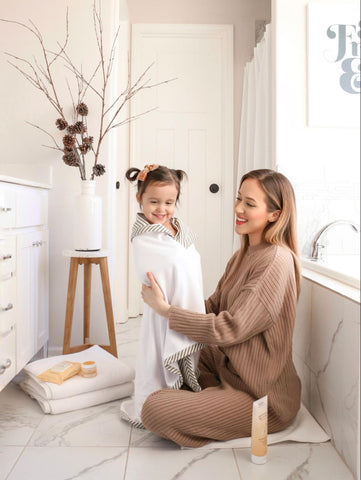 Mom wrapping up child in towel after oatmeal bath