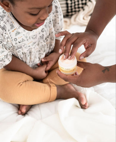 Mom applying Babo Botanicals Miracle Moisturizing Cream which is an oatmeal bath in a bottle!