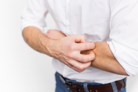 Man scratching his scaly skin