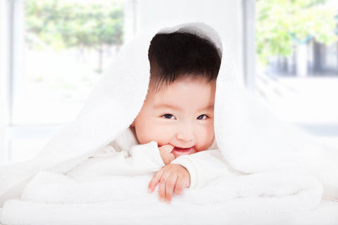 smiling baby under blanket