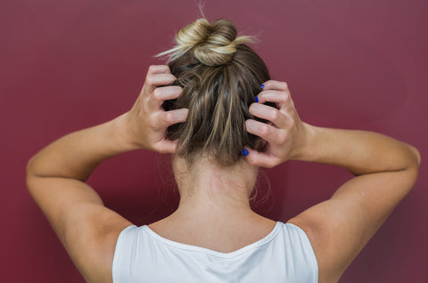 Woman with a bun itching her head