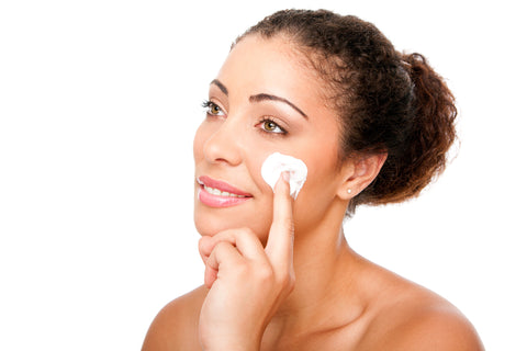 Woman applying cream on her sensitive skin