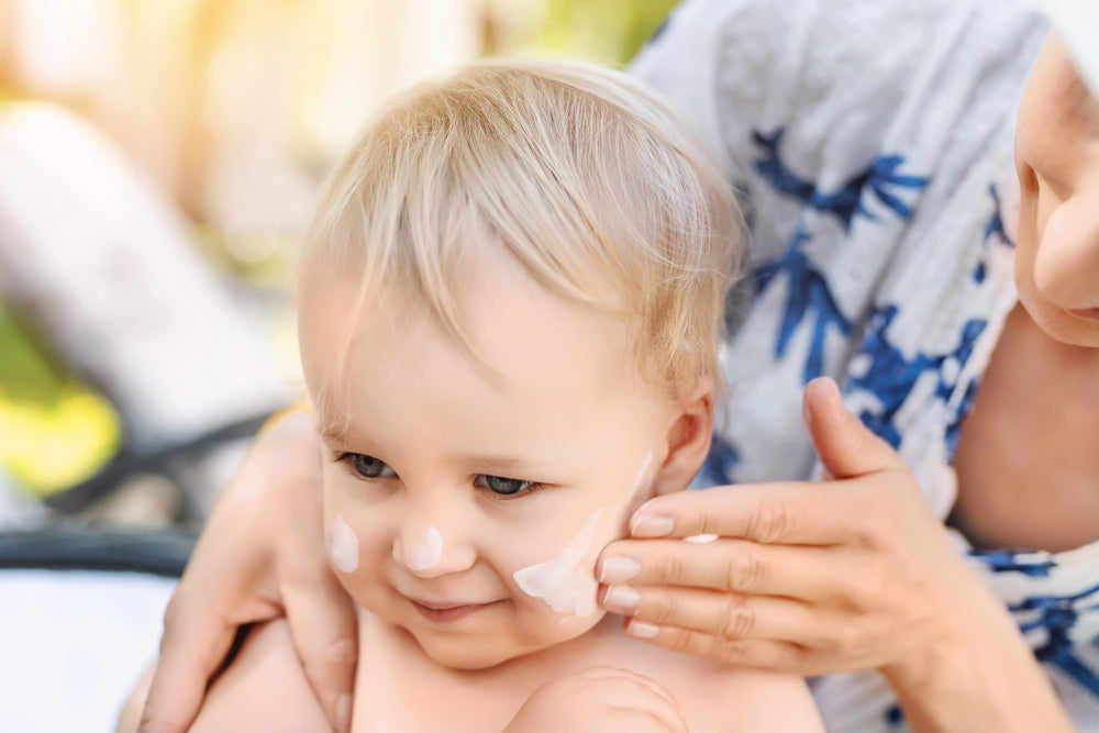 Mom applying sunscreen to baby