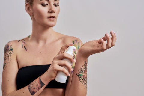 Woman applying tattoo aftercare products 